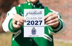 Graduate holding a personalized Class of 2027 graduation announcement